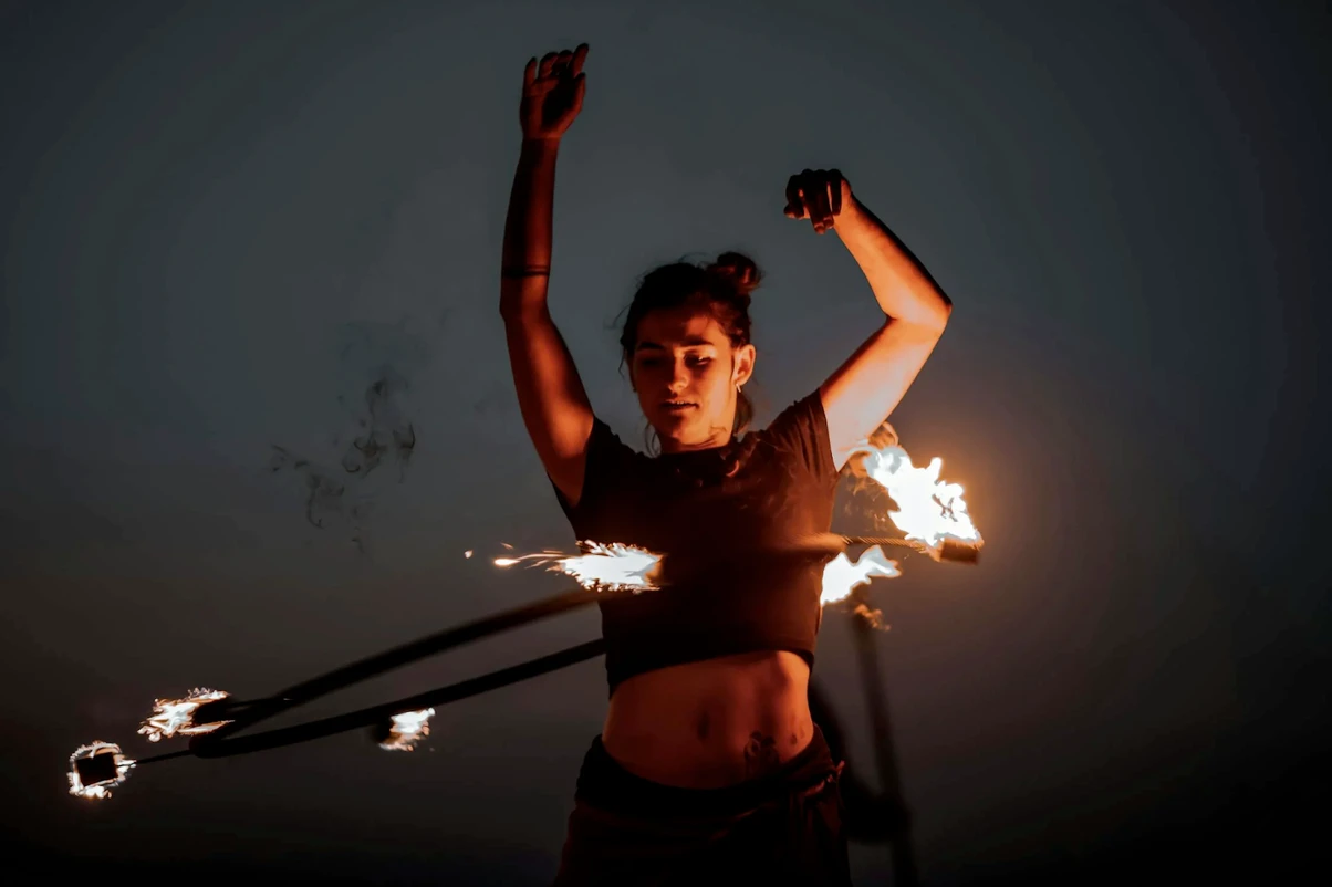 A fire dancer spinning a flaming hula hoop