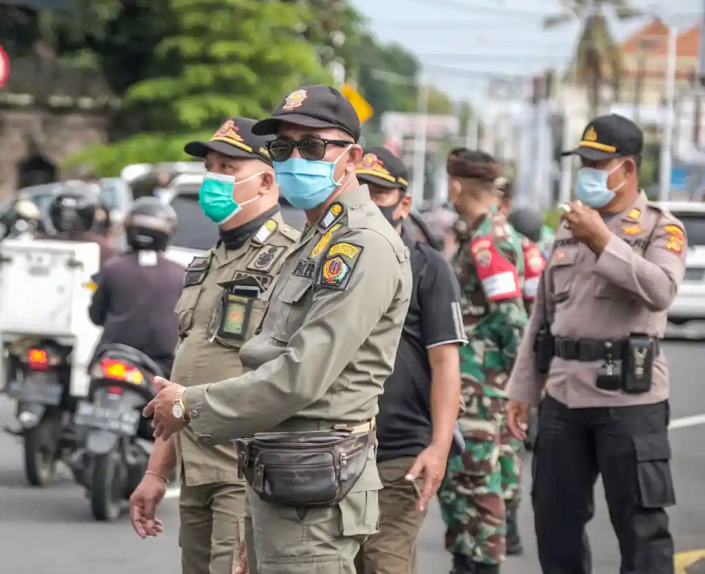 Indonesian security officers wearing face masks on street
