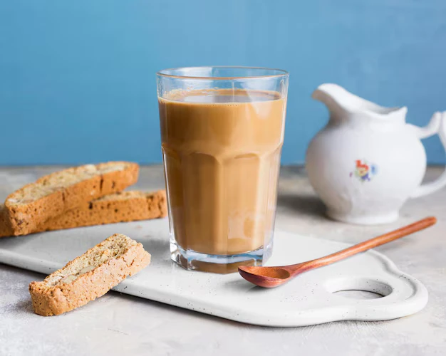 Glass of Teh Tarik served with biscotti and creamer