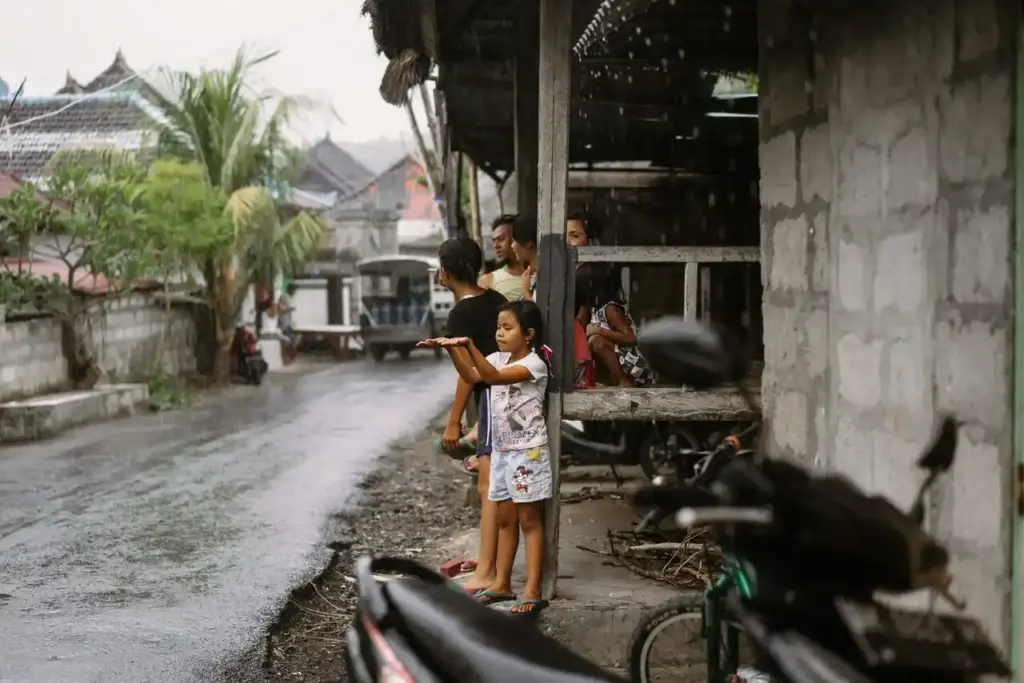 Children playing in the rain on a street
