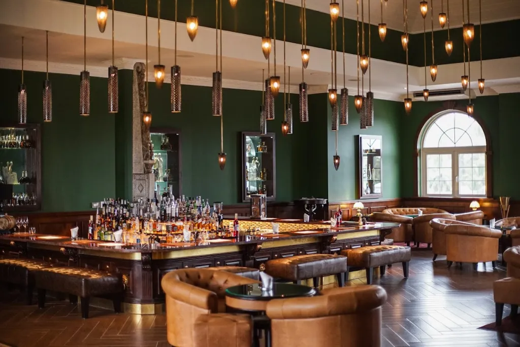 Elegant bar with green walls and pendant lights