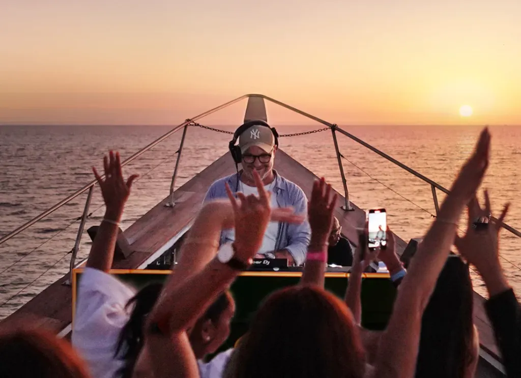 DJ performing on a boat during sunset