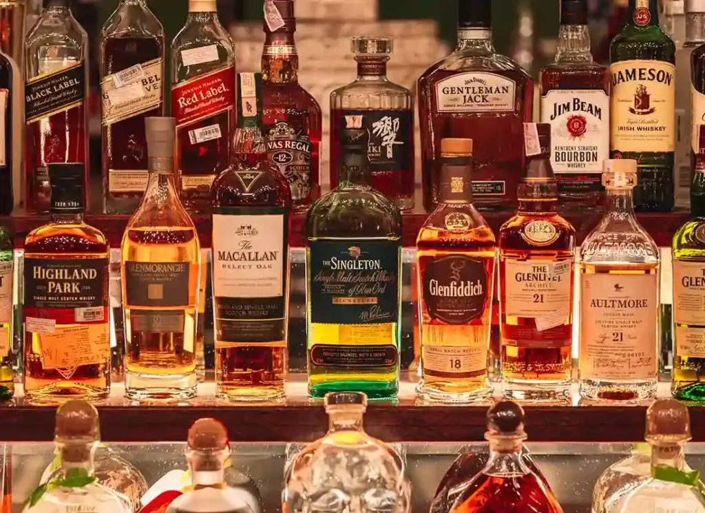 Selection of premium whiskey bottles on lit shelves