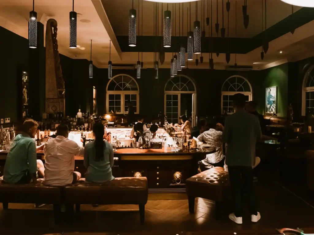 stylish Ubud lounge bar with guests enjoying drinks under warm pendant lights and elegant decor