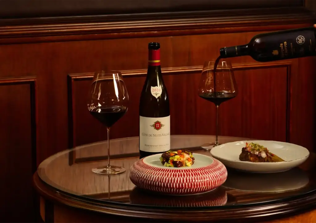 Elegant dining with Côte de Nuits‑Villages 2020 red wine and gourmet plated dishes