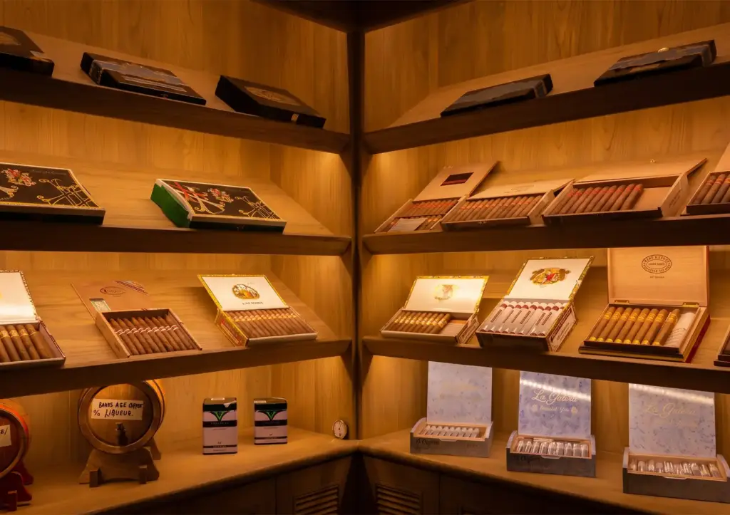 Elegant cigar display at a Cigar Lounge Ubud, wooden shelves filled with premium boxes and warm ambient lighting highlighting the collection.