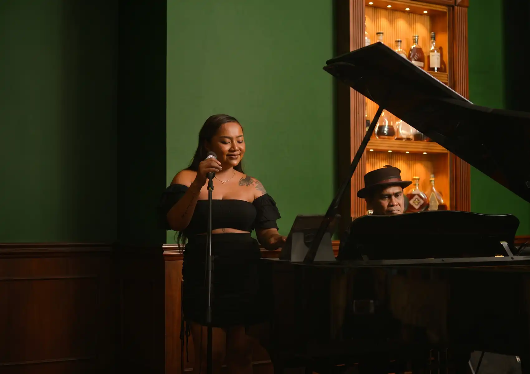 A live jazz performance featuring a singer and pianist in an elegant venue, offering night entertainment at a cocktail bar in Ubud.